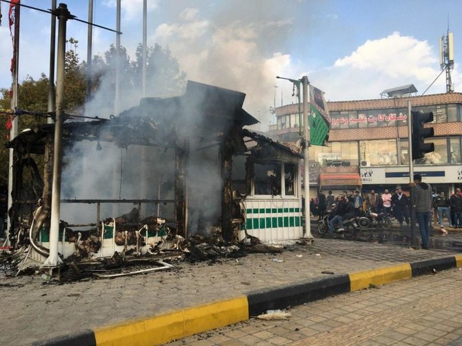 デモ隊によって放火され黒焦となった警察署の周りに集るイラン人たち。（ファイル/ AFP）